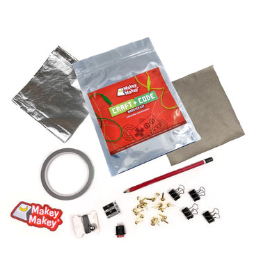 Makey Makey Craft + Code Booster Kit contents spread out on a table